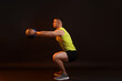 © New Africa - Man exercising with medicine ball on black background