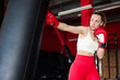 © New Africa - Boxing. Woman practicing with punching bag in training center