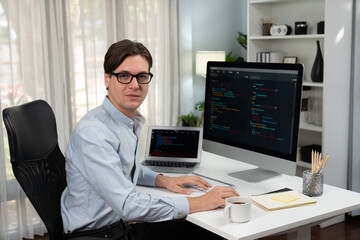 it developer looking camera with online software development information while working on pc and lap