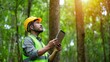 © David Zarzosa - Environmental engineer in forest using tablet under sunlight for nature assessment and urbanization possibilities.