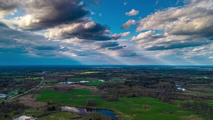 Wall Mural - timelapse of shifting clouds over patchy green farmland and forest lines