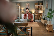 © Migma_Agency - Smiling freelancer working from home reading notes and using laptop