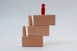 © Isman - Stack of wooden blocks and human icon on top on white background