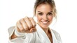 © Kelly - Smiling woman in white karate gi, waist-up, performing a basic punch, generative ai