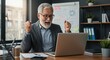 © DianneF - Photo of Happy Senior Businessman Celebrating Success at Laptop in Office