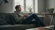 © DianneF - Photo of Man Sitting on Sofa Relaxing With Cup in Apartment Indoors
