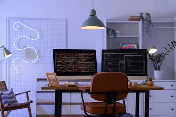 Wall Mural - programmer's desk with computer monitors and glowing lamps in office
