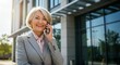 © Harry - Mature Businesswoman Talking on Phone Near Office Building Outdoors