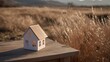 © yang - Dream house model on a wooden table in an open field, symbolizing simplicity and aspiration.