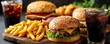 © Tin - Calorie bomb taste with sugar, salt, and greasy snack concept. Delicious burgers with fries and drinks on a wooden platter.