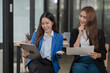 © Thitisak - Two young female businesswomen are meeting in an office.