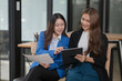 © Thitisak - Two young female businesswomen are meeting in an office.