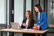 © Thitisak - Two young female businesswomen are meeting in an office