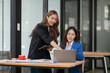 © Thitisak - Two young female businesswomen are meeting in an office.