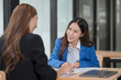 © Thitisak - Two young female businesswomen are meeting in an office.