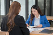 © Thitisak - Two young female businesswomen are meeting in an office