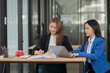 © Thitisak - Two young female businesswomen are meeting in an office