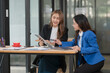 © Thitisak - Two young female businesswomen are meeting in an office
