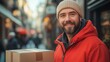 © Prostock-studio - A smiling man in a red jacket holds a package on a bustling street filled with people.