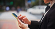 © peopleimages.com - Hands, city and phone with woman on social media, job texting and internet scroll in Japan with business commute. Email, digital news and web search outdoor with travel with maps app on mobile