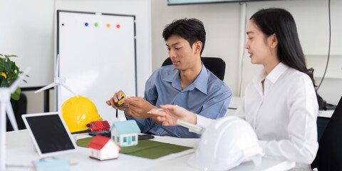 Wall Mural - sustainability and engineering. two engineers discussing eco-friendly design solutions with models a