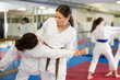 © JackF - Women students athletes at Academy of martial Arts practice karate and fight opponents in pairs. Obtaining black belt, advanced training, highest dan of martial arts. Sport to max. .