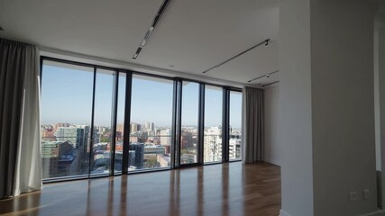 Poster - Spacious modern apartment with large windows, city view, wooden floor, and bright natural light, creating serene urban retreat