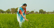 © Raushan_films - Indian gen x adult farmer woman lady wear saree standing outdoor farmland holding tab device browsing website looking screen Asian smiling female use calculate data yield outside rural area desi life