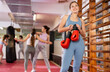 © JackF - Woman athlete with boxing gloves pose before training in gym, female sport team leader during students workout process. Coaching staff of school of box and self defense