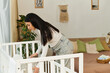 © Bliss - Beautiful pregnant woman prepares nursery in cozy modern home for welcoming new baby