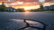 © Johannes - Cracked asphalt road in front of residential homes at sunset