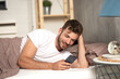 © Cherries - Happy handsome man lying in bed using cellphone
