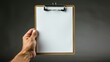 © PhotoMax - Person gripping clipboard with empty sheet of paper against a clean white background