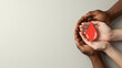 © Milan - Diverse hands cupped together holding a red paper blood drop. Unity in donation concept banner. Copy space for text. World blood donor day.