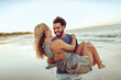 © Marko Geber - Young couple on a date having fun on a sandy beach next to the ocean during sunset