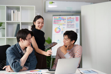 Wall Mural - collaboration and creativity. three graphic designers discussing design concepts and brainstorming i