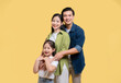© Q88 - A smiling family: mother father and daughter hug on a bright yellow background full of love