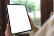 © Farknot Architect - Mockup image of a woman holding digital tablet with blank white desktop screen