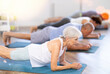 © JackF - Mature woman train during hatha yoga pilates lesson, perform exercises and stretches to improve physical health. Senior female participant working out practice elbow plank
