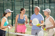 © JackF - Senior couple and their daughters discussing padel game in court