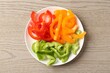 © New Africa - Slices of fresh colorful bell peppers on wooden table, top view