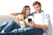 © ty - Young couple watching online content in a smart phone sitting on a sofa on a transparent background