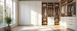 © miss irine - Bright modern walk-in closet interior design. White cabinet and shelves with clothes. Home interior with natural light, big window and green plant. Apartment storage design and storage space.