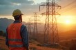 © Vadym - Electrical engineer looks at transmission towers during sunset. Construction worker wears hard hat near high voltage power lines. Energy industry, infrastructure, power generation, future tech