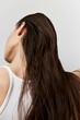 © SHOTPRIME STUDIO - Hair, beauty, profile, woman, studio, flowing, natural, healthy, texture, fashion, close up image of a woman with long, wet hair cascading down her back against a light background The focus is on the