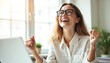 © miss irine - Happy female office worker celebrates success working with laptop. Cheerful businesswoman celebrates win, looking upwards, smiling. Excited young woman in eyeglasses, wearing white shirt in office