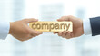 © photo for everything - A golden bar with the word 'company' is held by two hands, symbolizing business dealings, partnership, or ownership. Business exchange or new project.