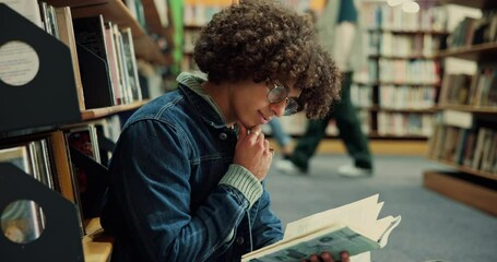 Poster - Man, reading or thinking with book in library for literature research, study or information. Male person, student or learner with textbook or novel for education, learning or knowledge by bookshelf