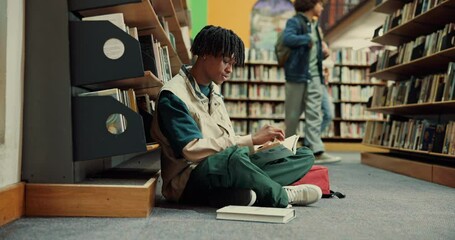 Poster - Man, student and reading with book in library on floor for education, learning or knowledge. Male person, learner or sitting with novel or textbook for literature or studying by bookshelf at college