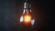 © Abdul - Vintage style light bulb with a glowing filament suspended in mid air against a dark background representing timeless innovation
